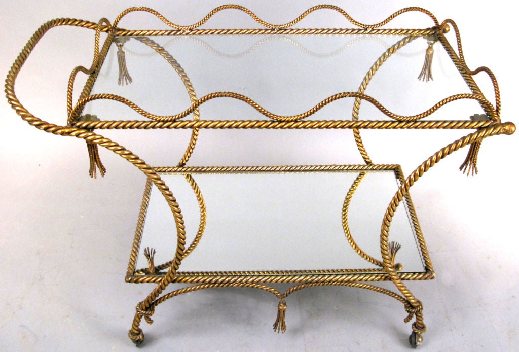 a fabulous vintage 1950's Italian rolling Bar Cart with a frame made entirely of gilt gold finished rope. beautiful design with wonderful details including a curving gallery rail around the top shelf, and tassels hanging from upper corners and from