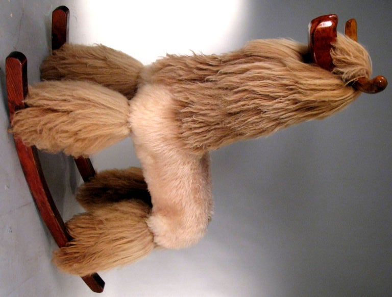 a wonderful and exotic life size rocking horse Llama, with a beautifully sculpted walnut head, horns, and rockers. having a wood frame with Llama pelts covering the legs, neck and head, and faux fur covering the body/seat. lies at the intersection