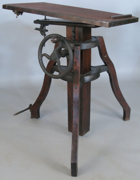 a very handsome and unique large adjustable camera stand, with 3 carved and curved legs, supporting double cast iron mounts with a cast iron wheel which adjusts the height of the stand. the top with a locking tilt adjustment as well. perfect for a