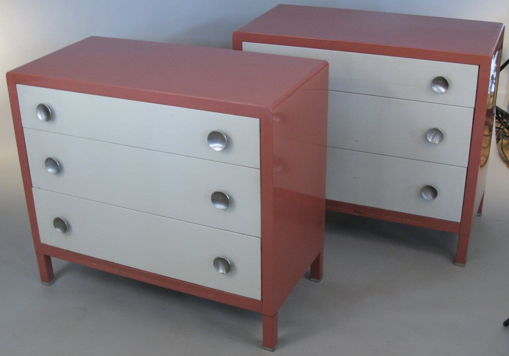 a pair of Norman Bel Geddes iconic and classic 1940's metal chests, in their original salmon lacquer with pale grey drawer fronts and natural steel drawer pulls. bel geddes was well known for this series of metal furniture and this is the classic 3