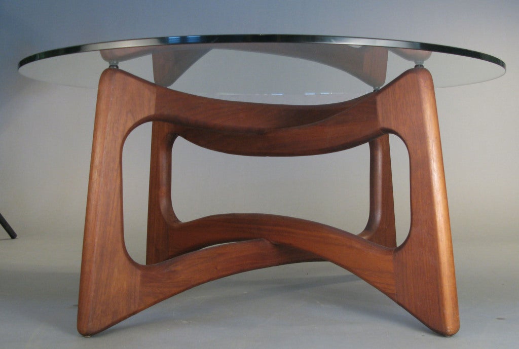 a very handsome and engaging vintage 1960's cocktail table designed by Adrian Pearsall for Craft Associates. the base formed by interlocking open forms in beautifully crafted walnut, supporting a round glass top. 

we also have the pair of