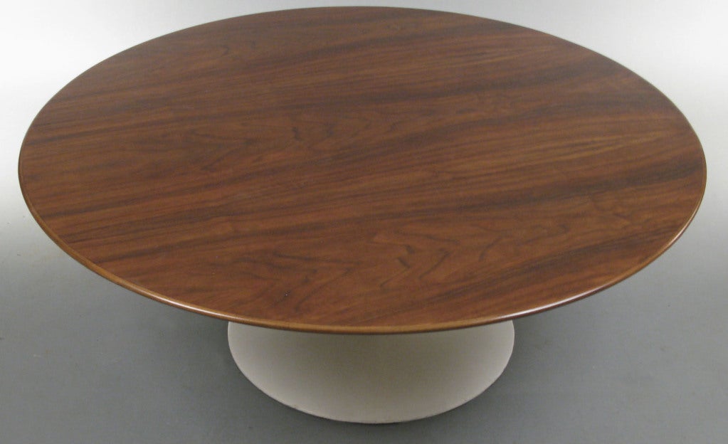 a classic and iconic vintage 1950's round walnut cocktail table designed by Eero Saarinen for Knoll. these 'tulip' tables are as modern and fresh as when they were designed over 60 years ago. cast iron base supports a large round walnut top with