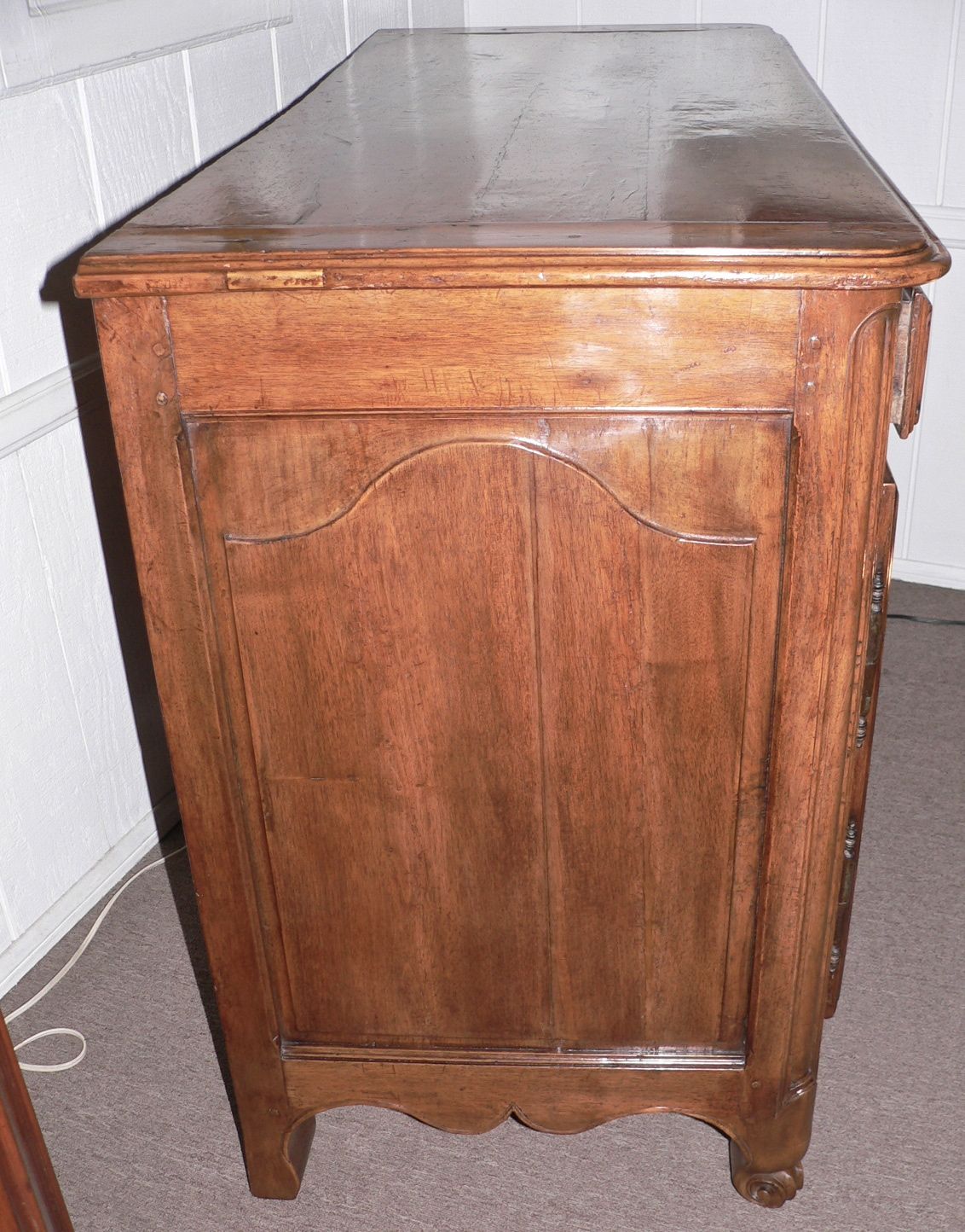 This buffet originates from the Rhone Valley and dates from 1830. It is made walnut with a figured applewood top. The side panels are slightly shaped. It is smaller in scale than the norm and has a beautiful light walnut color and patina. Hardware