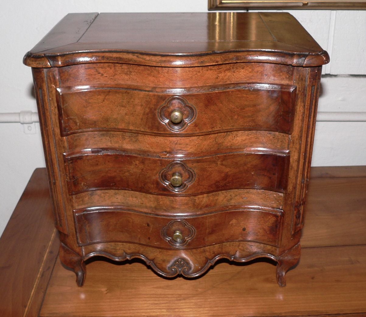 Beautifully crafted with great patina and color to the walnut. Fielded panelled sides and back with fluted columns. Dovetailed drawers lined probably with the orignial silk embroidered fabric. Original brass drawer knobs.   Galbee styling indicates