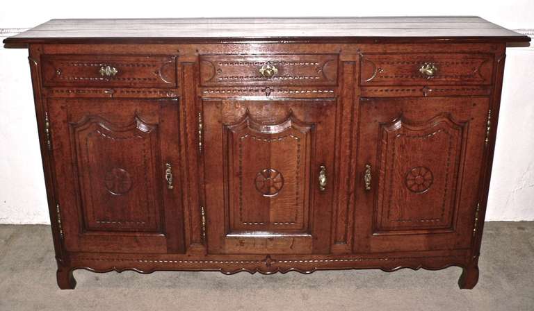 Originating from the Lorraine region of Eastern France, this enfilade has a very pretty color and patina with a clean and mark free top. The brass hinges and key plates are all original to the piece. The brass knobs are old but are later additions.