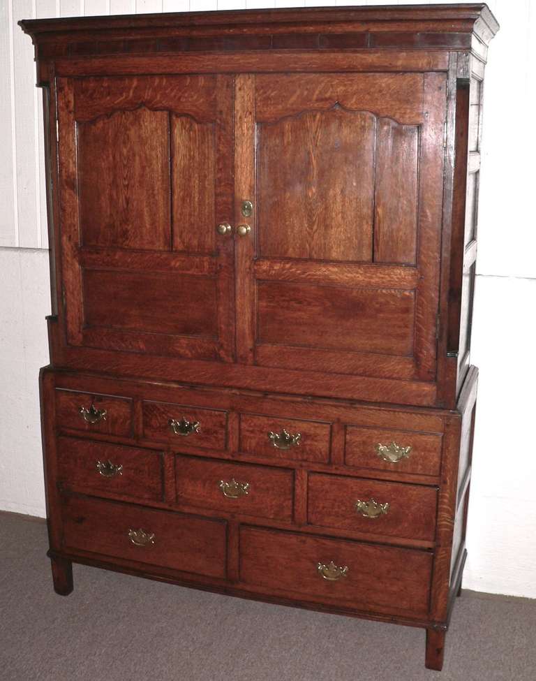 This very pretty and original cupboard has excellent color and proportion. The top row of drawers is false with the bottom two tiers being functional. The top section has been relined with new oak to support a swivel TV pullout bracket. It has a