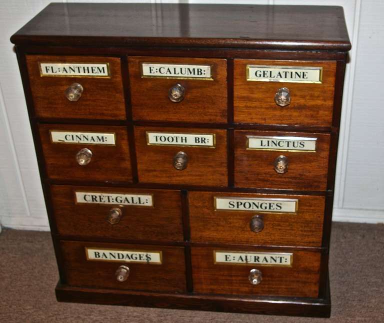 This small scale chest would be ideal for storage in a bathroom. It has a very attractive mahogany top with 10 drawers all together. It has the original glass drawer knobs. This is a newer chest made from Edwardian Chemist drawers. When the old