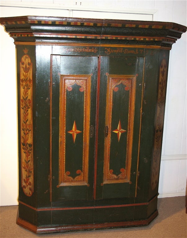 With the original paint and date enscription, this armoire has a very bold cornice along with fielded panel doors. The paint decoration is in excellent condition. The hinges are the original rat tail type. These armoires were constructed to break