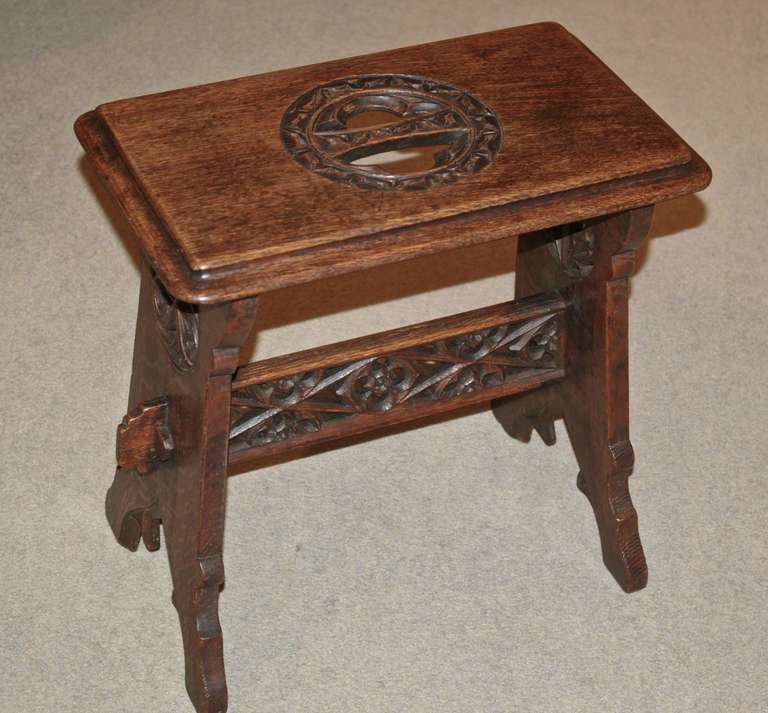 This stool has pierced carvings and is in near perfect condition. A very nice example of English Arts and Crafts Gothic Revival.  