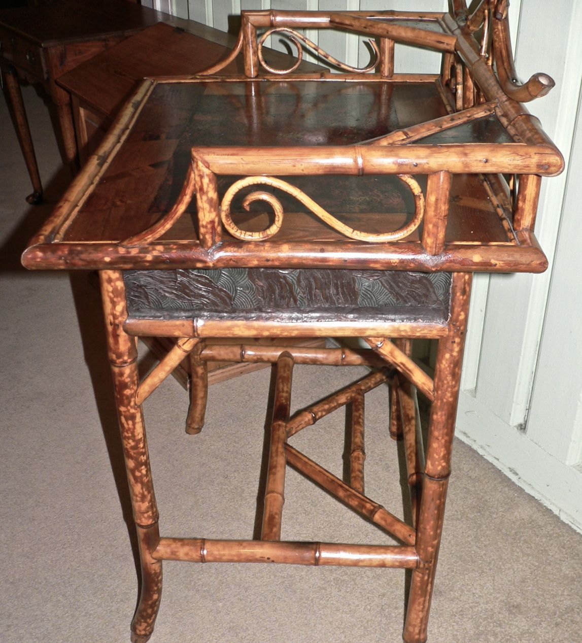 Very nice example of a late 19th century bamboo dressing table with a black lacquer top and drawer front along with embossed sides. All in very good condition. The drawer is dovetailed and has its original Edwardian brass ring pulls. The lacquered