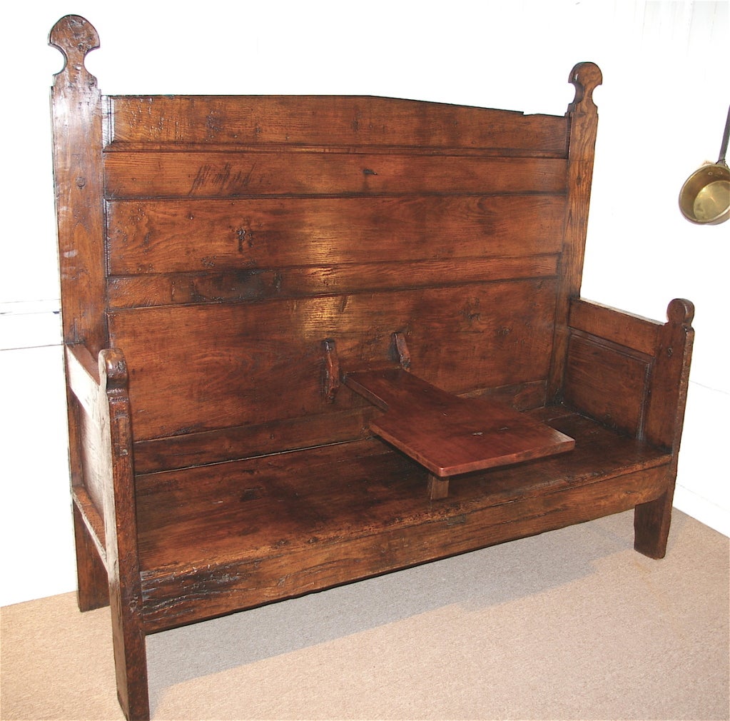A large scale and very impressive primitive Spanish bench with a rare drop down center table which was used as a work surface while sitting. The table folds up and latches shut. Beautiful color and wear to this bench  with panelled back and sides.