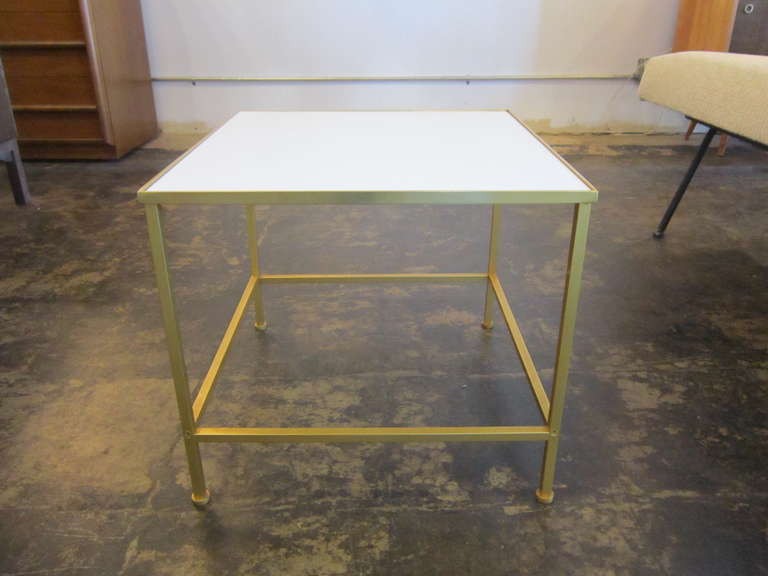 Brass based with a white vitrolite top side table.