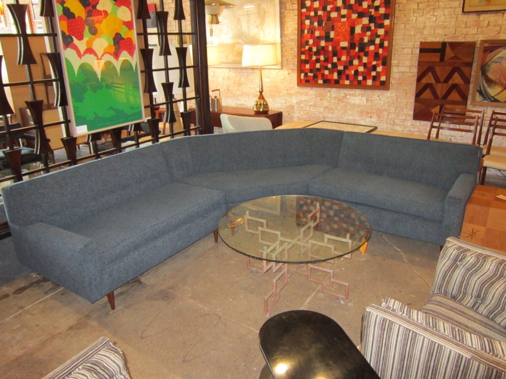 Three piece sectional sofa recently repholstered in a grey fabric.
