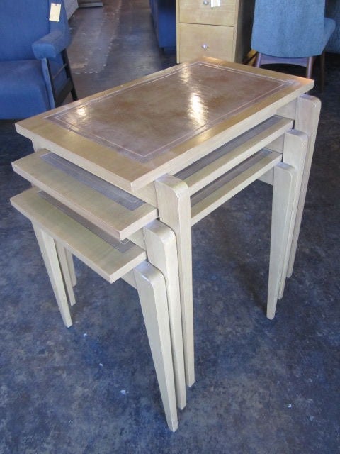 A set of three nesting tables with inset leather tops.  If you have any questions about this item or about shipping, please contact dealer.