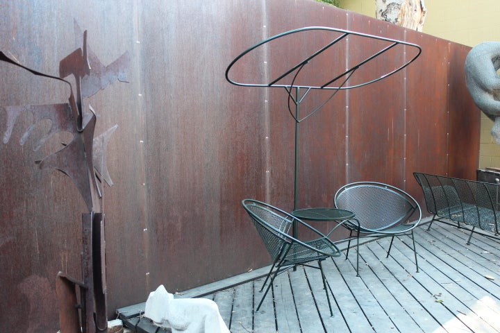 A newly powder coated tete-a-tete with removable umbrella by Salterini. Other matching pieces of outdoor furniture also available. There are two of these available.