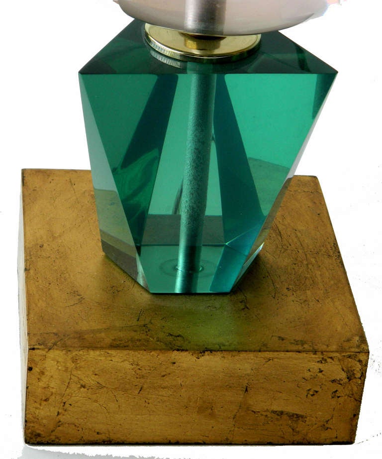 Lampe de table originale en lucite transparente et verte, de style moderne du milieu du siècle, de marque Van Teal.
Monté sur une base carrée en bois doré et livré avec l'abat-jour original.
Câblé aux États-Unis, en état de fonctionnement et accepte