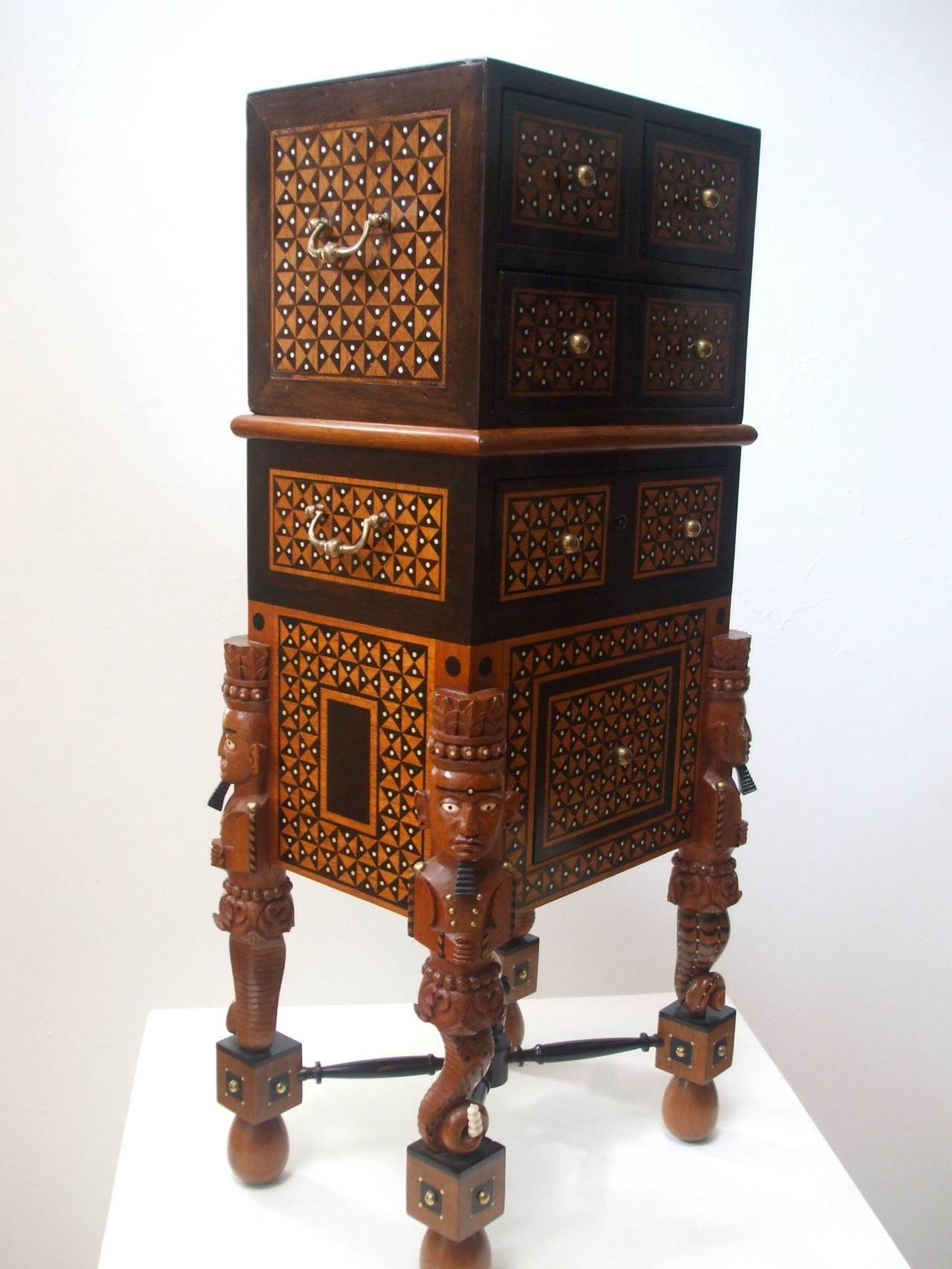 An amazing work of art inspired by and utilizing a late 17th, early 18th century Indo-Portuguese small three drawer table chest now on a carved and inlaid two drawer stand of teak, ebony and faux-ivory with custom bronze mounts by San Francisco