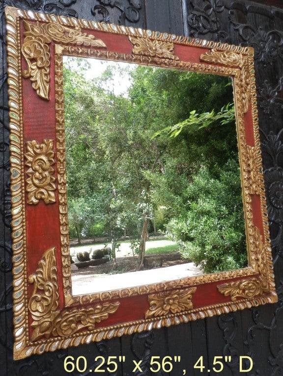 Spanish colonial style red frame with gold leaf and inlaid mirrors to reflect more light into a room.