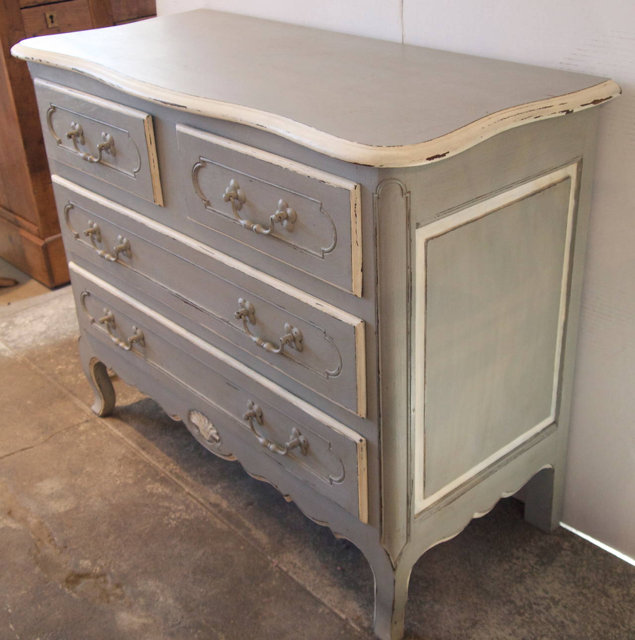 Nice and well proportioned and carved grey painted with white highlights four-drawer chest in the style of Louis XV, early 20th century.