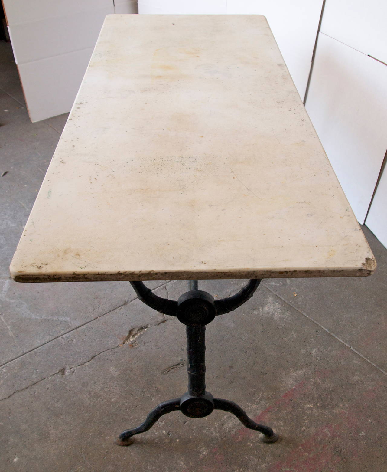 Very nice 19th C. French double bistro table with original marble top on a painted cast iron base of faux bamboo design