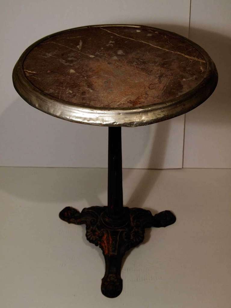 Marble top round bistro table with a beveled tin rim on a painted cast iron pedestal/tripod base