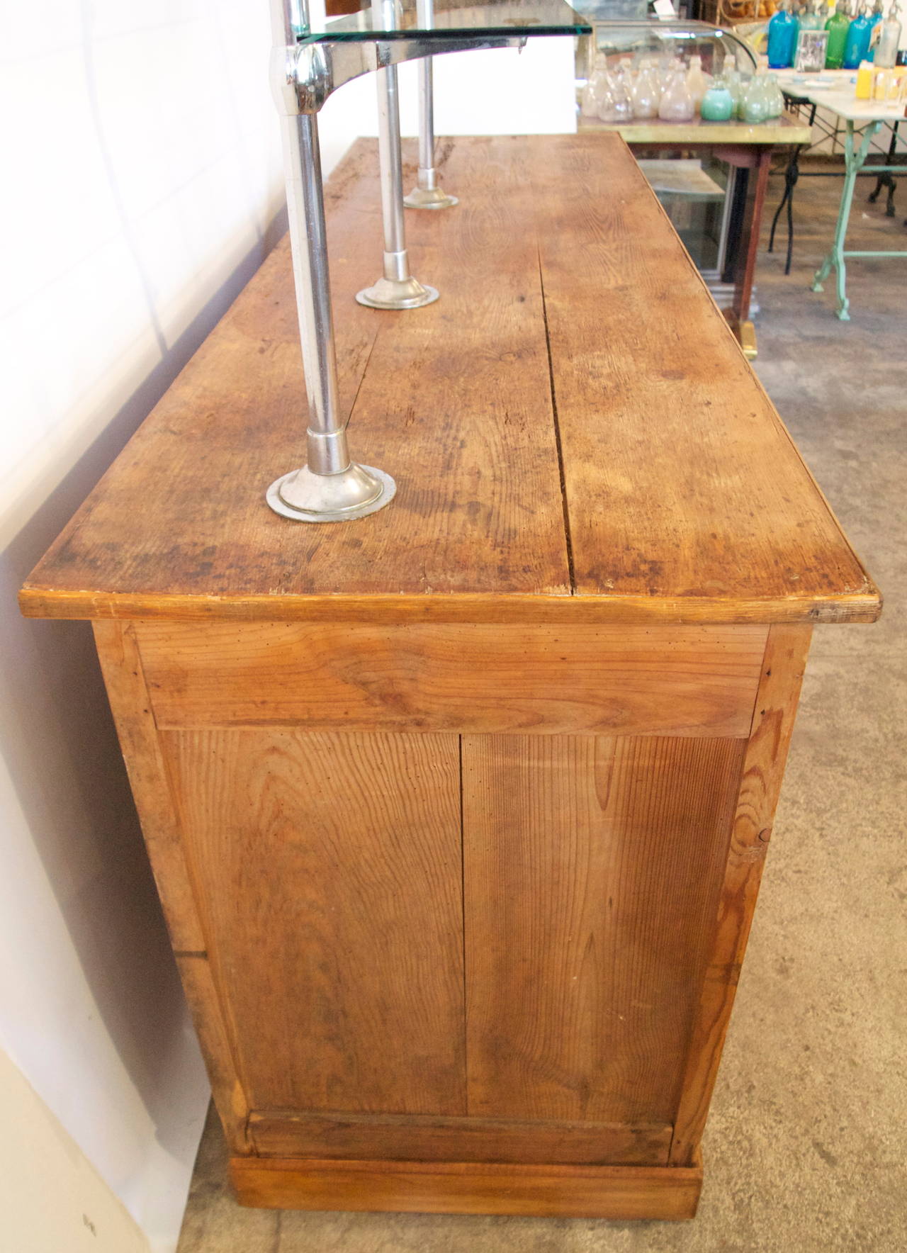 Attractive and useful French pinewood display counter with two adjustable  glass shelves, large storage back area and single small drawer from the early 20th century