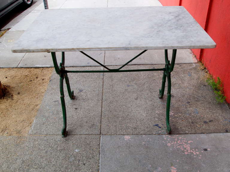 Marble top bistro table on green painted cast iron base from the early 20th century.