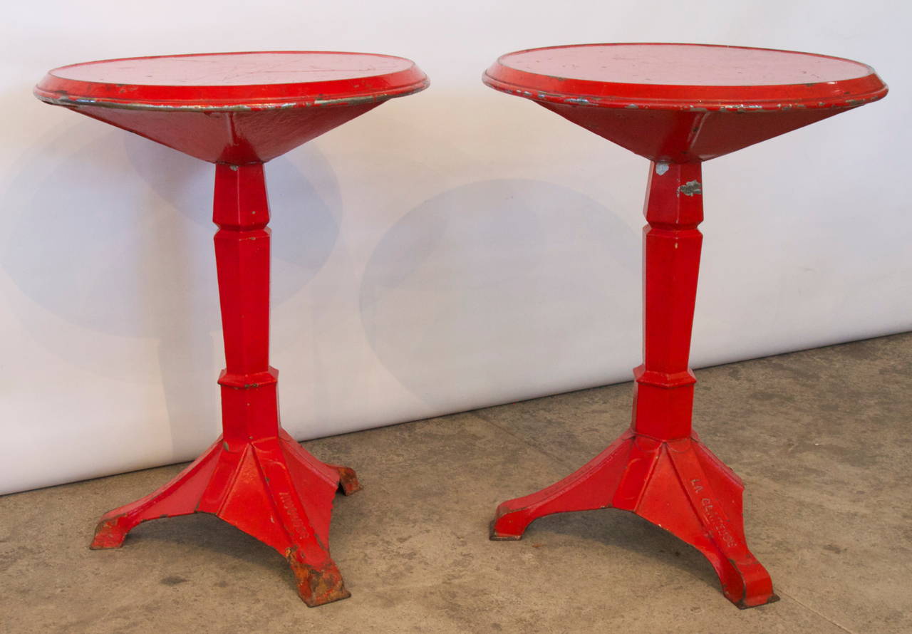 Wonderful and unique pair of red painted metal French Industrial bistro gueridon.  Bases marked La Glaneuse, Cadenet, Vaucluse, a region of Provence - Alpes Cote d'Azur, France, late 19th or early 20th century.
