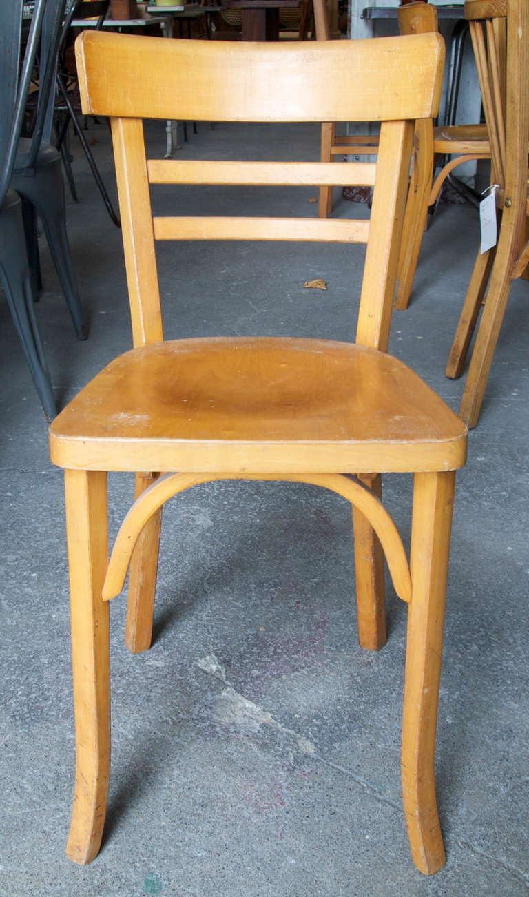 Set of 10 light stained wood bistro chairs manufactured by Baumann