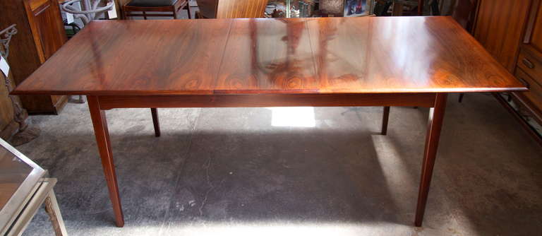 Very nice and elegant solid rosewood Danish midcentury extending dining table on tapered legs with one leaf.  (65