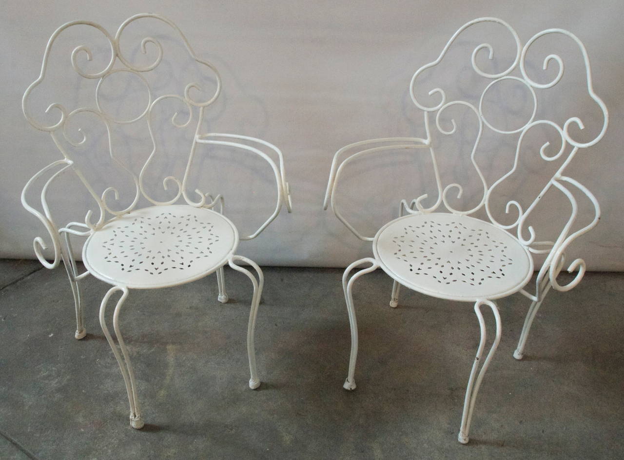 Decorative French white painted metal garden round table with matching pair of armchairs and side chairs.
Mid-20th C.
France
