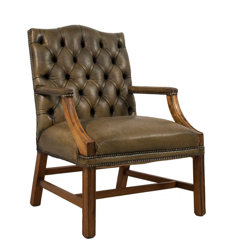 Tufted leather armchair with arms and legs in walnut.