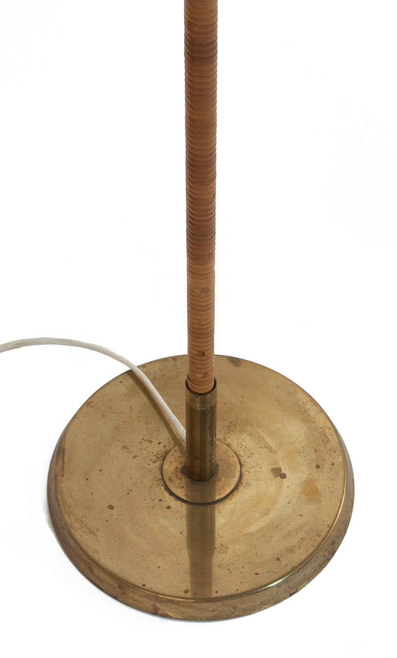 Floor lamp in brass and cane by Paavo Tynell.
