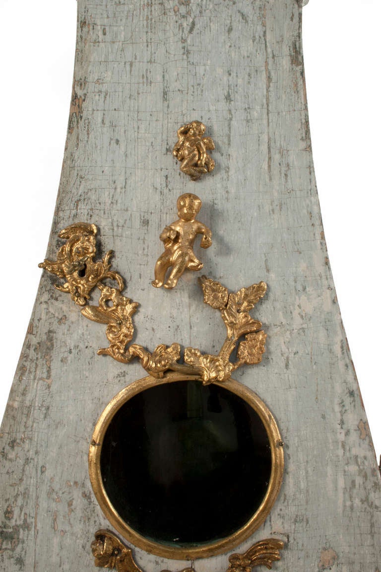 Rococo Grandfather Clock with gilded details and a worn pale grey/green patina.