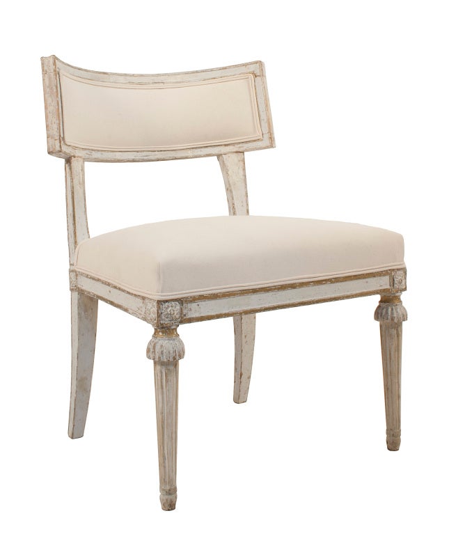 Pair of Gustavian Klismos Chairs in a worn light grey and gilded patina. The Klismos Chair had just been reinvented after recent discoveries at the excavations of Pompeii.
