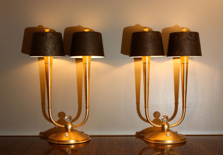 Philippe GENET (1882) & Lucien MICHON<br />
<br />
France Circa 1940<br />
<br />
Exceptional pair of gilt bronze lamps with two lights, mounted with two oxidized steel shades. Top in frosted glass, ball in crystal.<br />
Provenance: Sotheby's