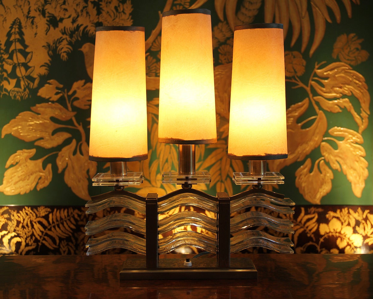 Marius-Ernest Sabino (1878-1961).

Spectacular pair of oxidized bronze and glass table lamps. Probably one of the most beautiful high-end models by Sabino.
Each glass wave has an amazing yellowish reflect with bubble inclusions, these beautiful