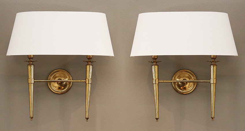 This elegant pair of brass sconces comes from a set of 69 sconces we acquired from the Prince de Galles Hotel in Paris. The sconce bodies are all in their original condition from 1940 and each have varying degrees of the natural patina. We have had