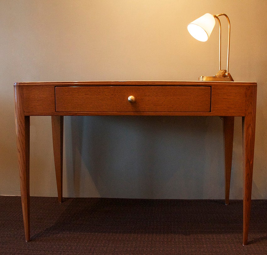 Rare elegant desk by Emile-Jacques RUHLMANN in oak and ash with a suede top and a single large drawer with a brass knob. 

This very rare desk was part of the interior design for the student rooms at a University in Paris in the 1930s. Only 20 of