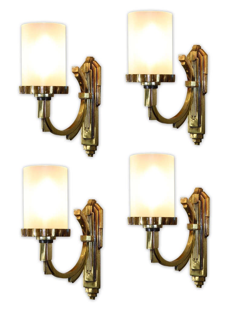 Maison Petitot, Pair of Sconces, France, circa 1930.<br />
Two Pairs of gilt bronze sconces by Maison Petitot. Tubular frosted glass lampshade.<br />
Measurements: Height:12