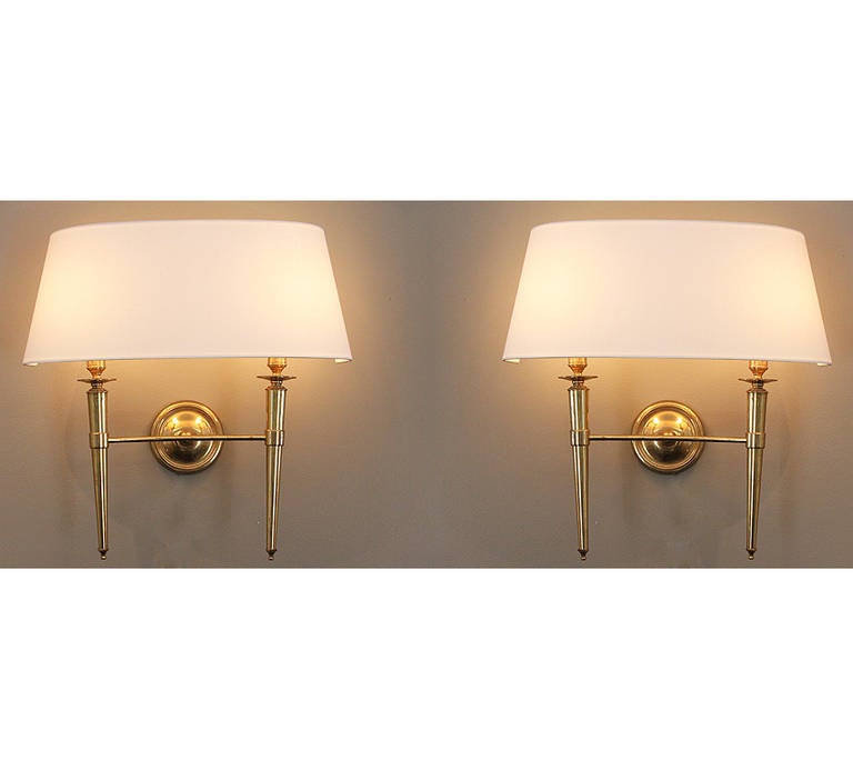 This elegant pair of brass sconces comes from a set of 70 sconces we acquired from the Prince de Galles Hotel in Paris. The sconce bodies are all in their original condition from 1940 and each have varying degrees of the natural patina. We have had