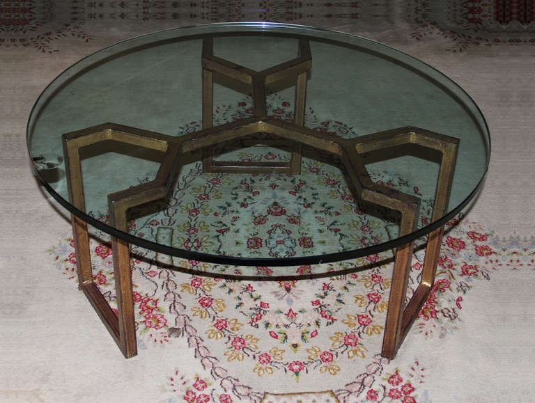 Elegant round gilt wrought iron coffee table. 
Table legs have a distinctive geometrical crab style form and a lovely natural patina. 
Model of Jean Royere.
France Circa 1960