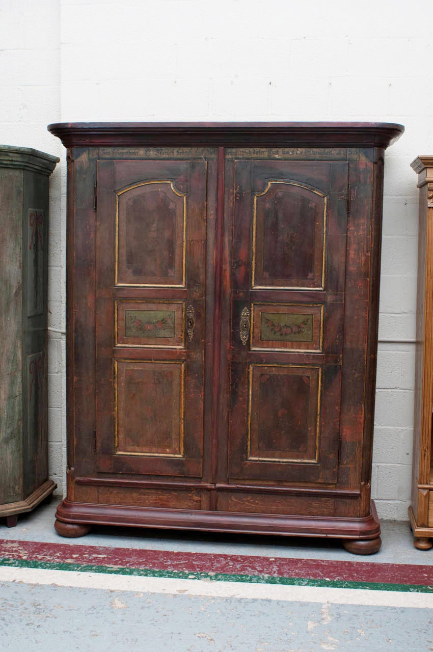 An outstanding two door Bavarian armoire in original paint, the six door panels with floral decoration, some of it exquisitely detailed.  Disassembles into two halves.  Replaced base and crown.
The poetic admonition, in gothic script, reads,