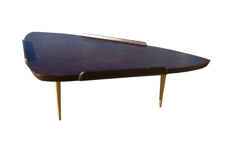 This classic mid-century styled table has an overhanging lip with open ends for sweeping away possible debris. Table is walnut with an ebonized top, creating a two-tone look. Table is three legged, allowing a sweeping view of table's unusual design