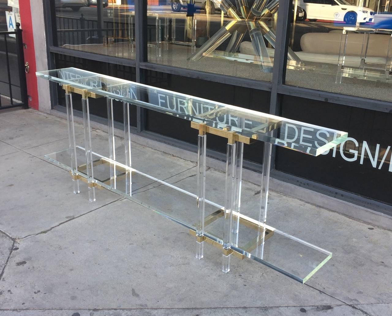 1960s design executed in brass and Lucite long and narrow console table designed and manufactured by Charles Hollis Jones in Los Angeles California.
The table is part of is 