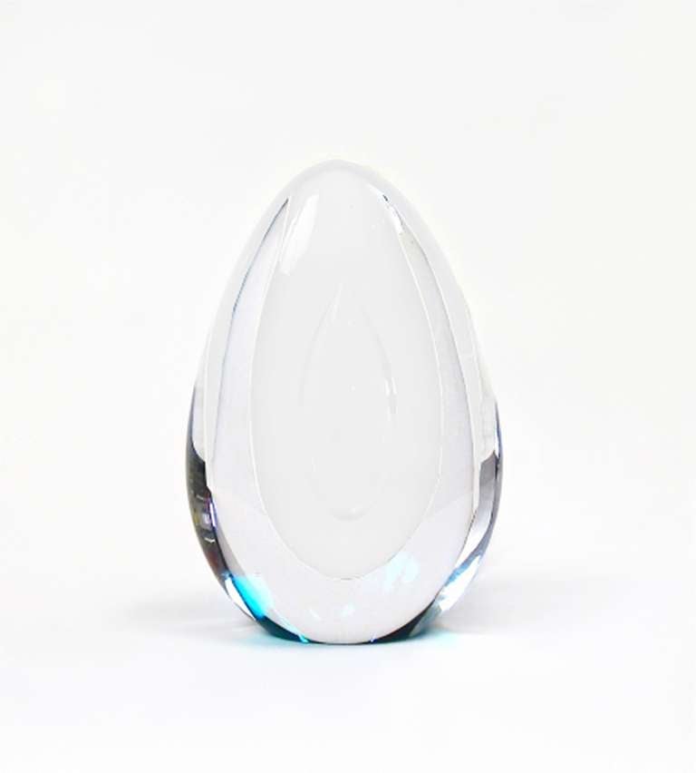 Art glass egg designed by Mona Morales-Schildt for Kosta Boda. Clear glass with a large bubble in the middle. 
Morales worked for Wilhelm Kage 1935-38, for Arabia 1939-40, and as an artist for Kosta, Sweden 1958-76.

The sculpture is no