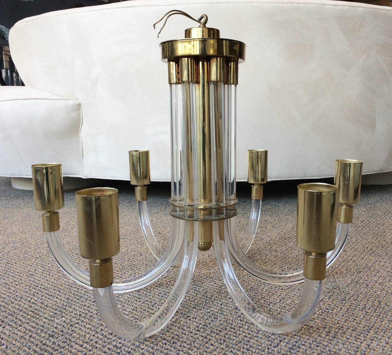 Fantastic Lucite and brass chandelier designed by Charles Hollis Jones in the 1960s.
The way the chandelier is made is very ingenious; the individual Lucite arms are casted Lucite embedding the electrical wire in the Lucite which gives you a