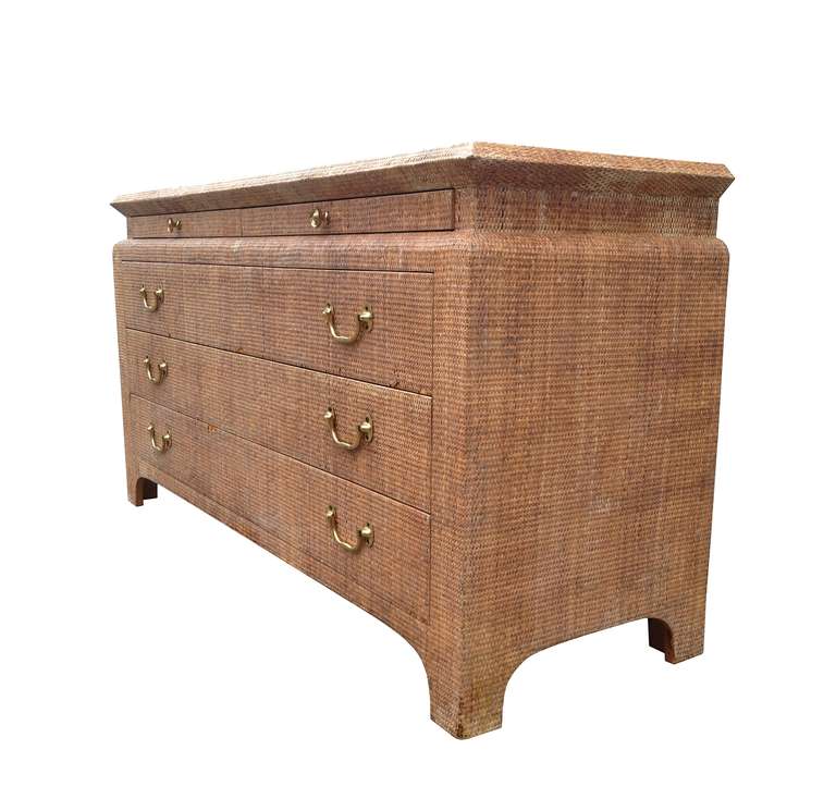 Stunning raffia embossed five-drawer dresser. The dresser is very well designed and built, the frame is solid wood and embossed in raffia and finished in a reddish color. The back of the cabinet is also finished but in a brownish color, there at