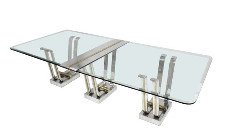 Stunning dining table designed by Karl Springer and mnufactured by Karl Springer LTD.

The table is comprised of 3 chrome and brass bases that can actually be separated and used as consoles or one smaller dining tables.

The piece is in