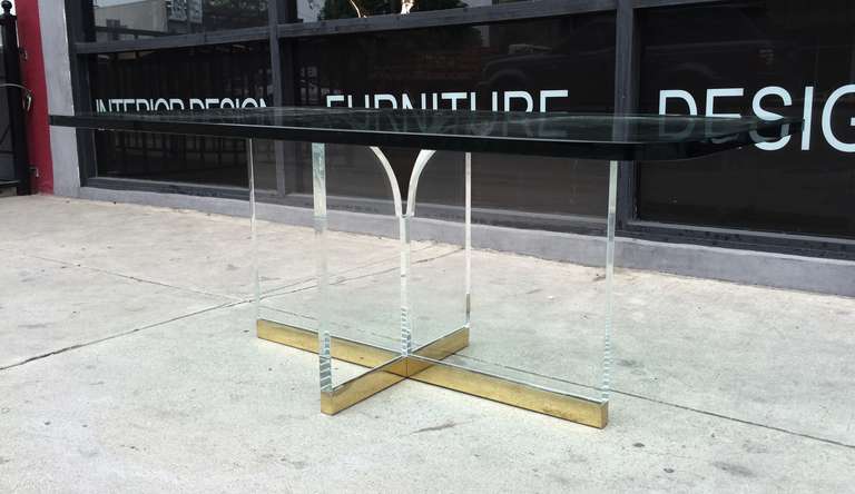 Stunning coffee table in Lucite and brass designed and manufactured my Charles Hollis Jones in the mid-1970s. The table is very delicate to the eye and yet very imposing in design appeal, they combination of metal is perfect and the execution out of